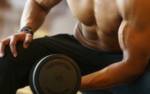 topless man holding dumbbell