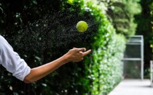 person throwing tennis ball